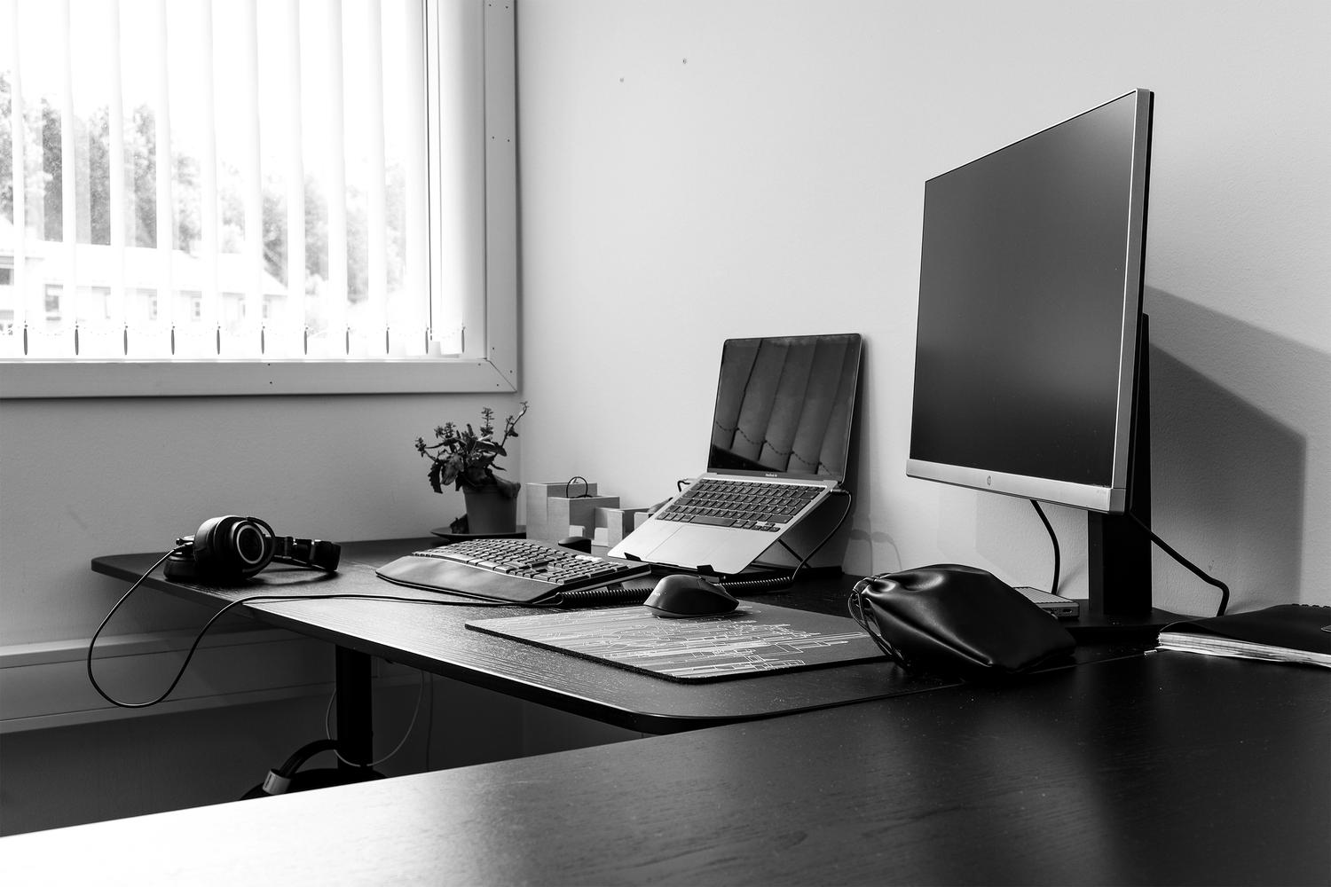 Monitor och en bärbar dator på ett kontorsskrivbord